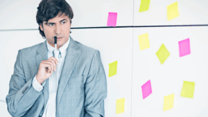 A person thinking while sticky notes are on the background