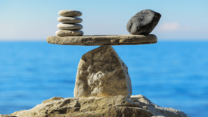 An image of stacked rocks balancing over a bigger rock