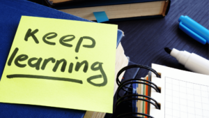 A sticky note placed on a notebook with a written text saying "Keep learning"