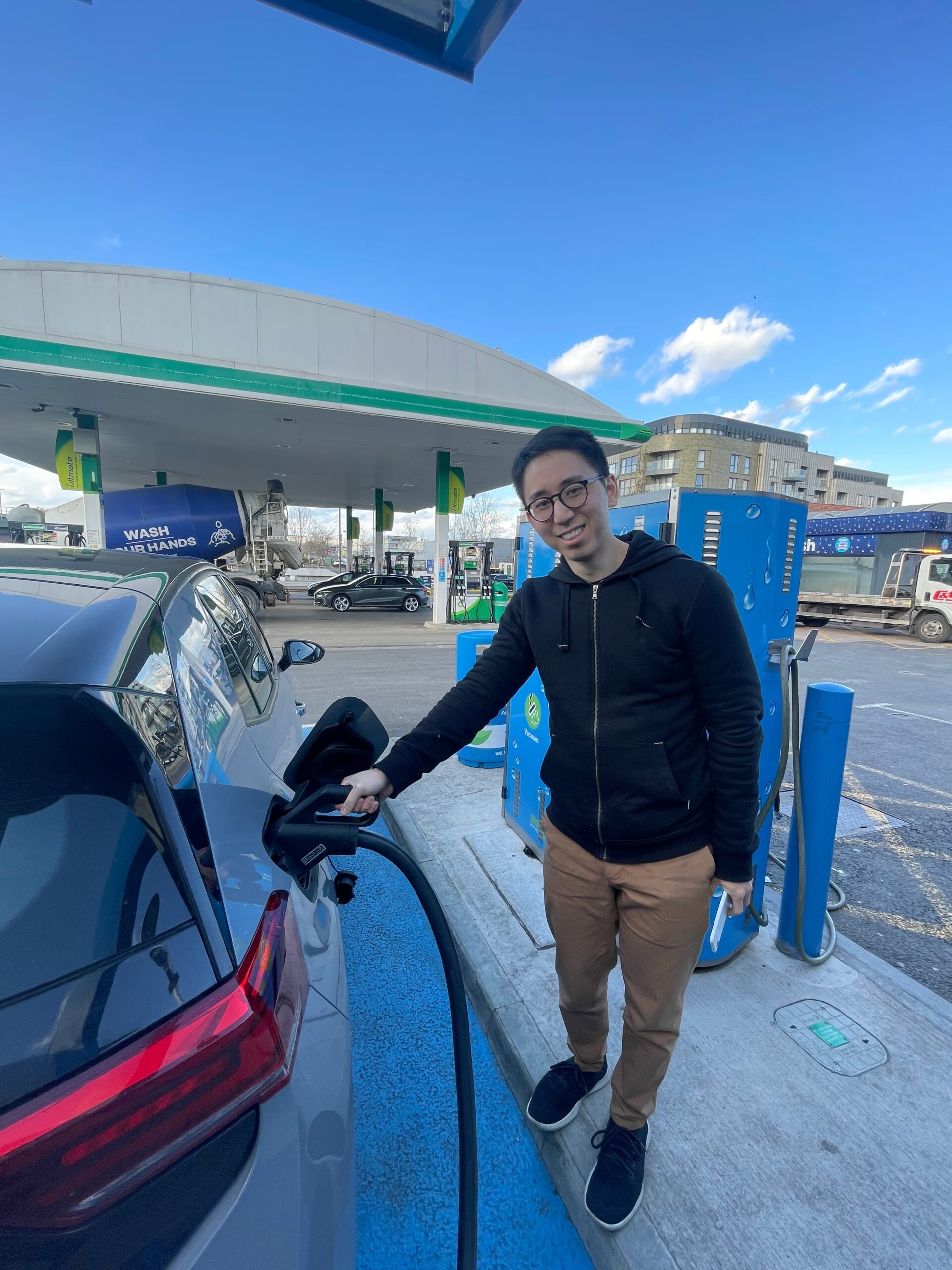 Elvin smiles whilst connecting the car to a charging point.
