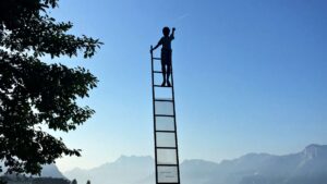 child on the ladder reaching for shooting star, portraying ambitions